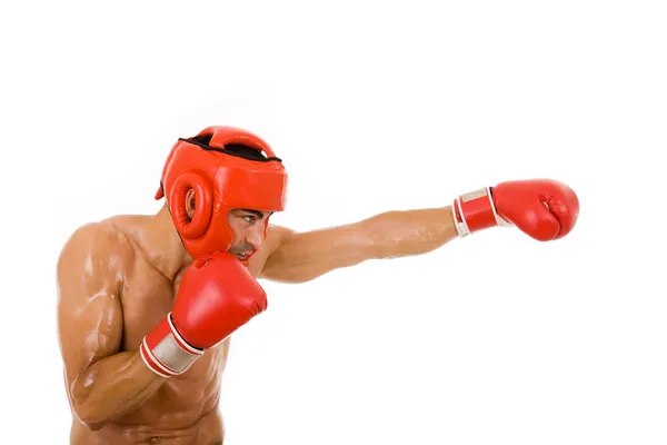 Молодой боксёр в боксерском шлеме и перчатках наносит удар — стоковое фото