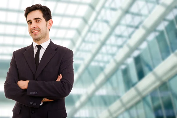 Closeup of a young smiling business man standing at modern offic — Stock Photo, Image