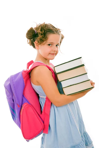 Счастливая маленькая школьница с грудой тяжелых книг — стоковое фото