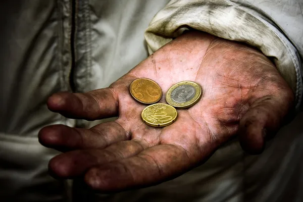 Нищий с монетами на грязных руках — стоковое фото