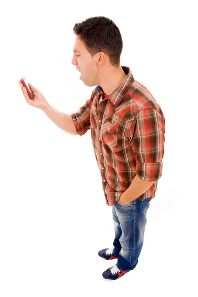 Angry young man screams into the mobil phone over a white backgr — Stock Photo, Image