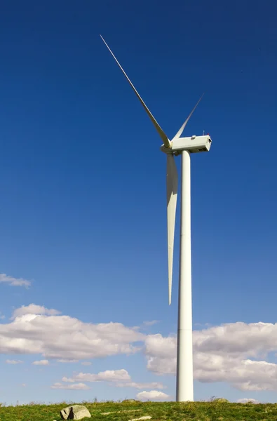 Witte windturbine opwekking van elektriciteit op blauwe hemel — Stockfoto