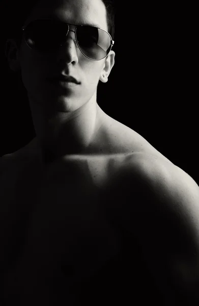 Nackte muskulöse männliche Modell mit Sonnenbrille, low key — Stockfoto