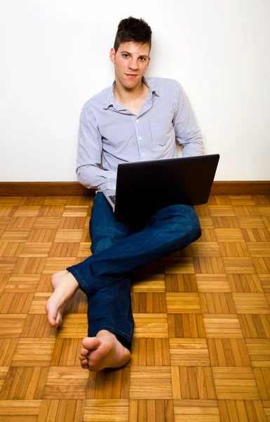 Szczęśliwy człowiek dorywczo w domu przy użyciu komputera przenośnego — Zdjęcie stockowe