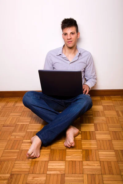 Hombre casual feliz usando el ordenador portátil en casa —  Fotos de Stock