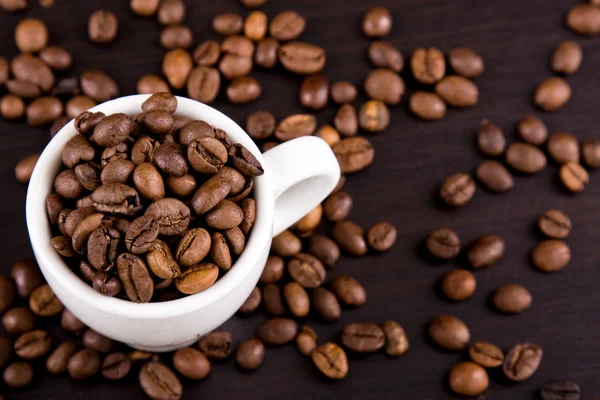 Xícara de grãos de café na mesa — Fotografia de Stock