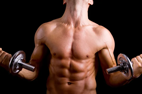 Muscular jovem homem levantando halteres — Fotografia de Stock