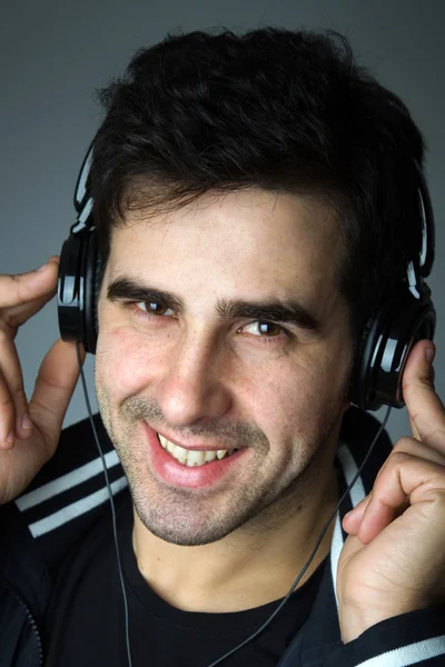 Pohledný mladý muž poslouchá hudbu — Stock fotografie