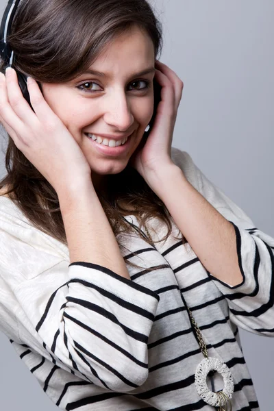 Sorrindo jovem mulher ouvindo música — Fotografia de Stock