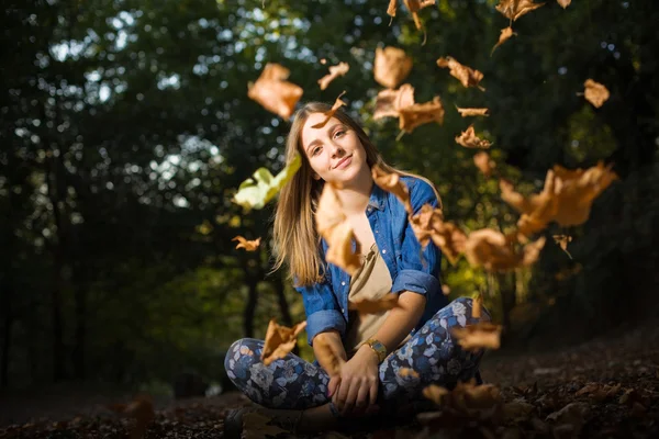 Beautiful young girl with falling leaves — Stockfoto