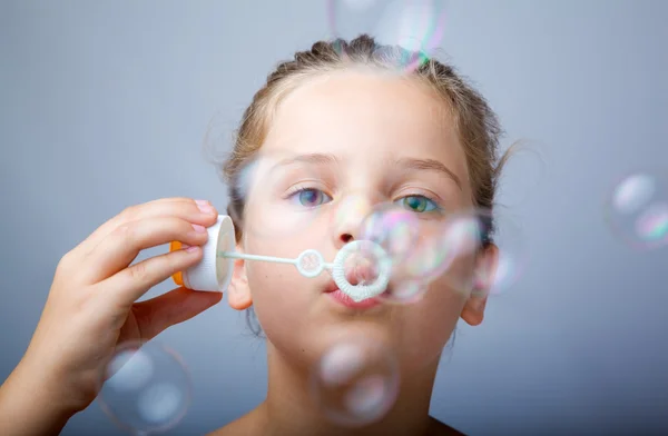 stock image Little girl blowing soap bubbles