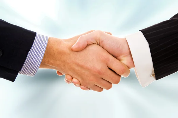 Närbild av ett handslag mot oskärpa bakgrund — Stockfoto