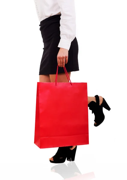 Kadın kırmızı bir alışveriş çantası taşıyan belden aşağı görünümü — Stok fotoğraf
