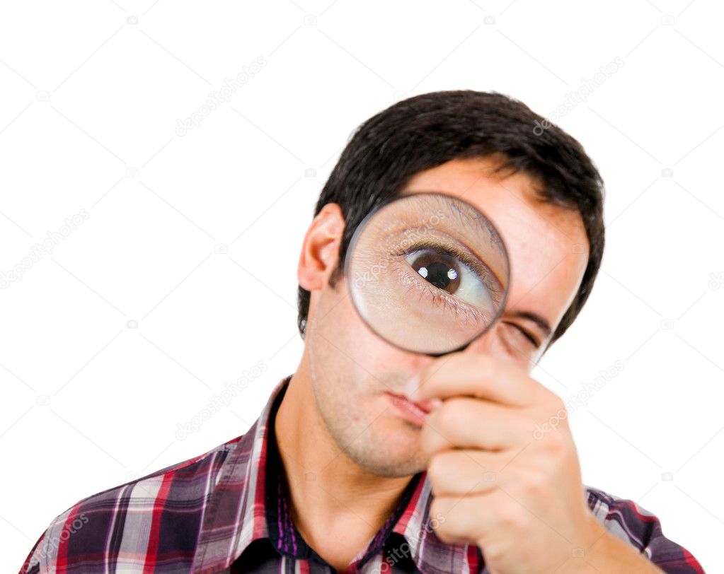 Young man looking through magnifying glass