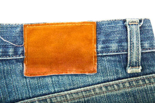Blank label on used blue jeans — Stock Photo, Image