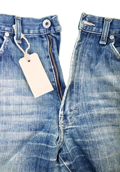 Unbuttoned blue jeans with paper label — Stock Photo, Image