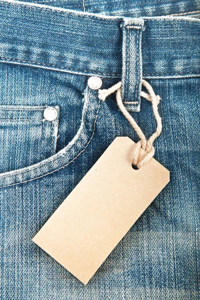 Blue denim jeans with paper label — Stock Photo, Image