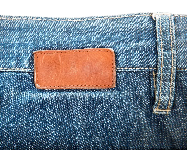 Etichetta in pelle bianca cucita su blue jeans — Foto Stock