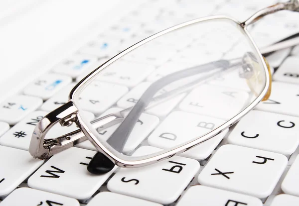 Bad vision. Glasses on keyboard — Stock Photo, Image