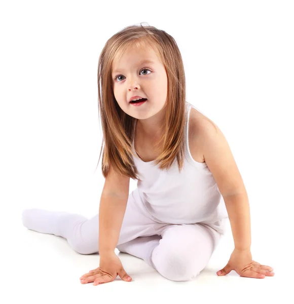 Una hermosa niña se sienta sobre un fondo blanco. Aislado — Foto de Stock