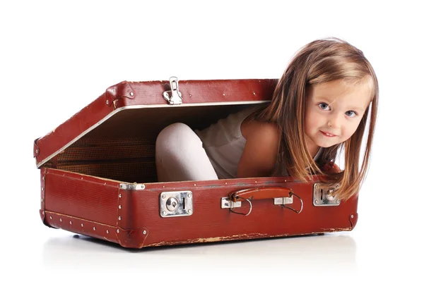 stock image Happy small girl sitting in a suitcase. Travel concept. Isolated