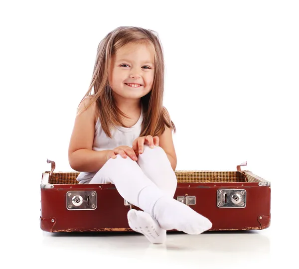 Criança pequena feliz sentada em uma mala. Viajar. Isolados em que — Fotografia de Stock