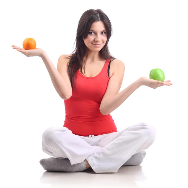 Young woman in a pose of a lotus, with apple and orange. Isolate — Stock Photo, Image