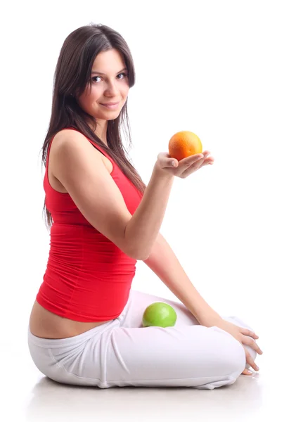 Молода дівчина тримає яблуко та апельсин. Ізольовані — стокове фото