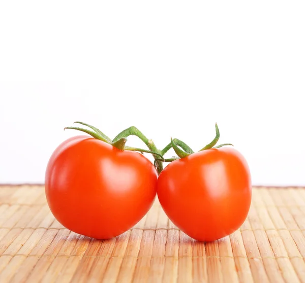 Red raw two tomato with a branch. On wooden board — Stock Photo, Image