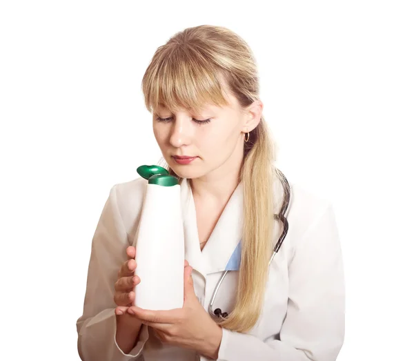 Doctor sniffing a bottle of cosmetic — Stock Photo, Image