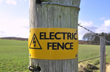 Electric Fence Sign in the Countryside clipart