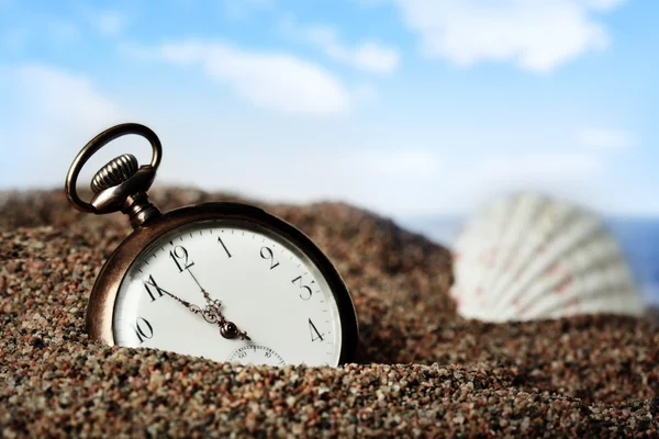 Velho relógio de bolso enterrado na areia — Fotografia de Stock