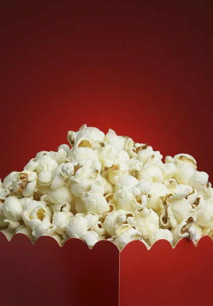 Schachtel Popcorn und roter Hintergrund — Stockfoto