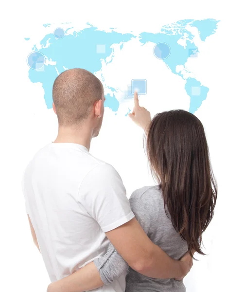 Couple looking at a virtual touch screen world map — Stock Photo, Image