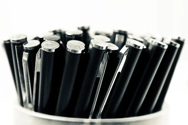Черно-белое фото с ручками в контейнере, изолированное на белом фоне — стоковое фото