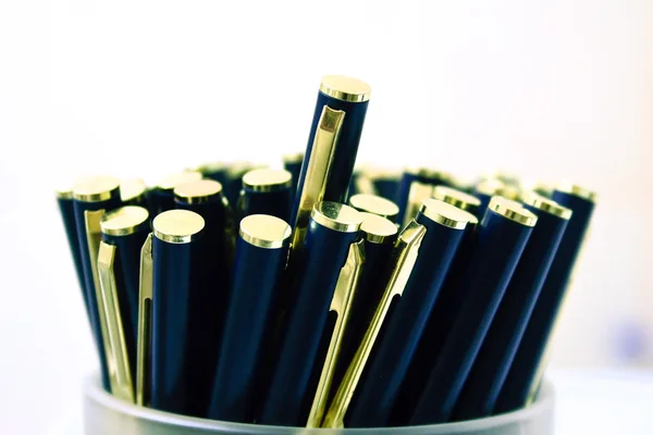 Макросцена с элегантными металлическими шариковыми ручками в контейнере — стоковое фото