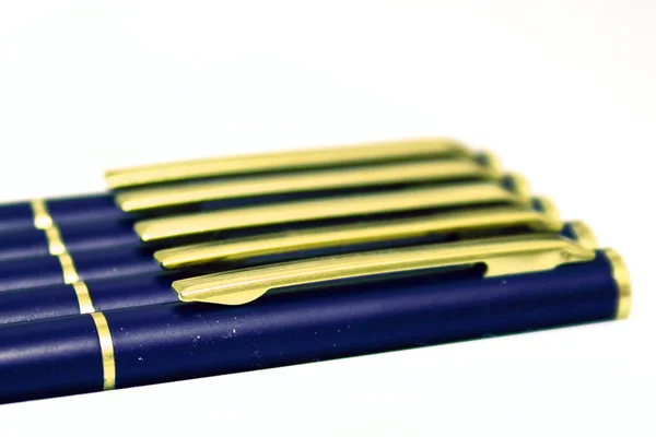 Ett foto av fem pennor över en vit bakgrund. — Stockfoto