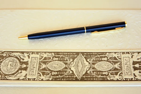 Металева ручка над ручним папером та значком для книг — стокове фото