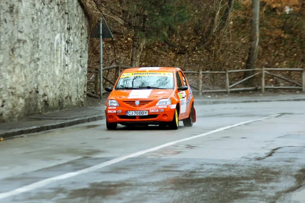 Orange Dacia Logan coche de carreras de rally en la competencia de asfalto carretera — Foto de Stock