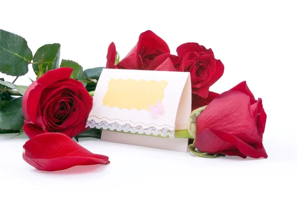 Rosas vermelhas com um cartão presente em branco — Fotografia de Stock