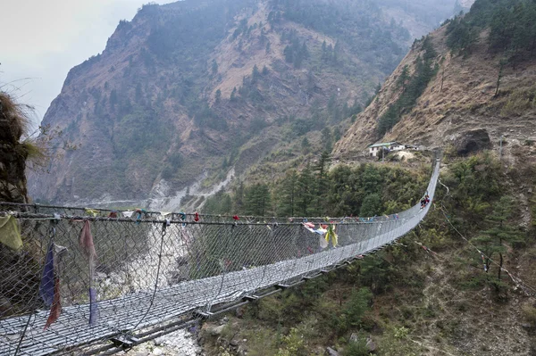Suspension foot bridge over valley in mountains, Himalaya — Stock Photo, Image