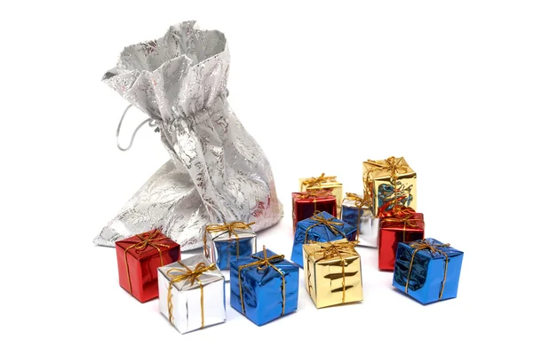 Az ajándékokat, amelyek csepegés ki egy ezüst táska-fehér hátsó Stock Kép