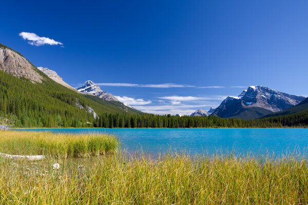 Lake with turquoise blue water, Rocky Mountains and clear sky
