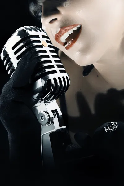 Женщина поет в винтажном микрофоне — стоковое фото