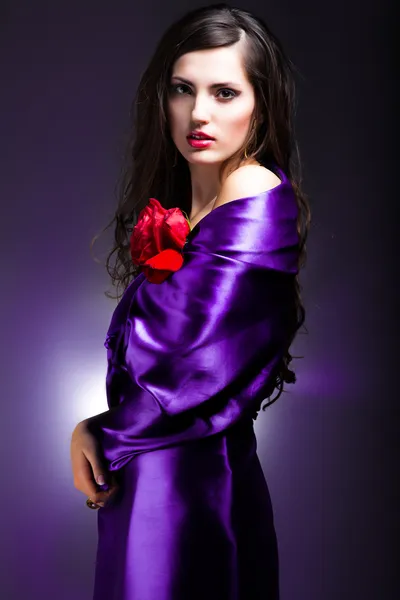 Portrait d'art d'une belle femme en robe violette avec rose — Photo