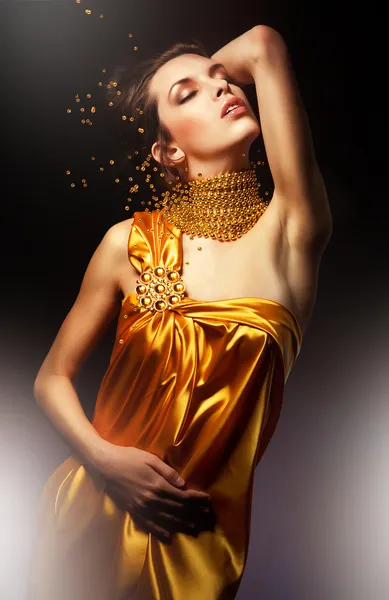 Mooie vrouw in lange jurk met sieraden — Stockfoto