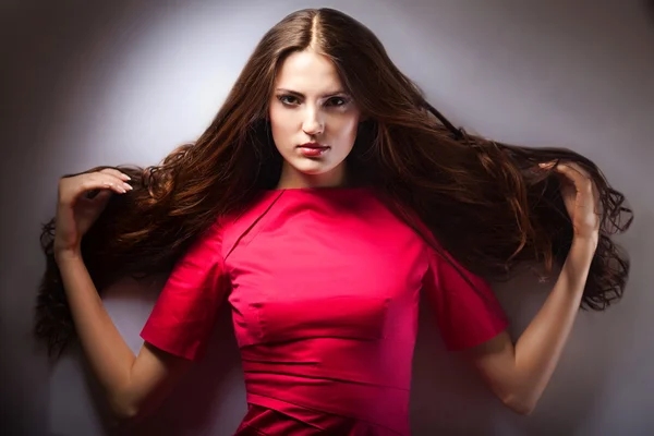 Vackra drömmande flicka med röda rosor i håret — Stockfoto