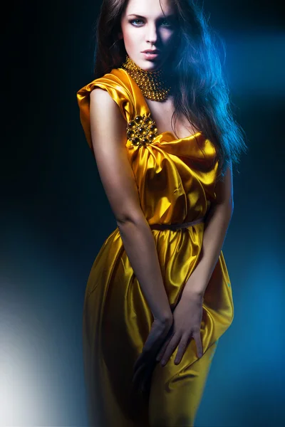 Mooie vrouw in lange jurk met sieraden — Stockfoto