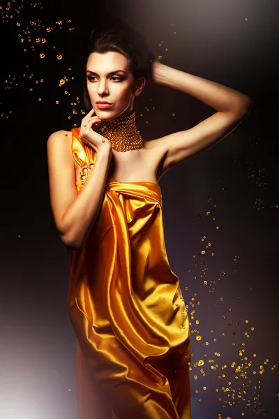 Frau im langen gelben Kleid und Schmuck — Stockfoto