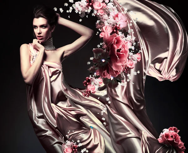 Aantrekkelijke vrouw in prachtige stof en bloemen — Stockfoto